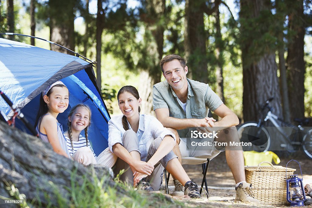 Família sentado ao ar livre em área de acampamento para barraca - Foto de stock de Acampar royalty-free