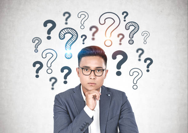 istock Asian businessman in glasses, question mark 1163784471
