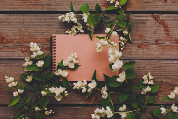istock Blank notebook with white flowers on wooden table. 1163785845