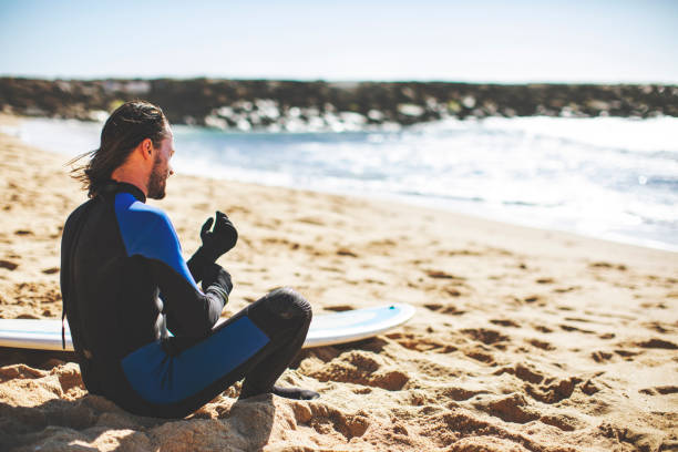 istock Man with surfboard at the beach 1163785907