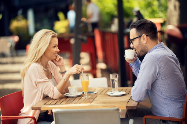 istock Happy couple talking to each other while relaxing in a cafe. 1163787161