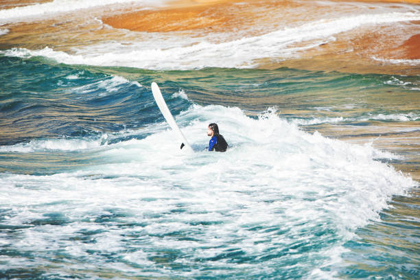 istock Man with surfboard at the beach 1163787168