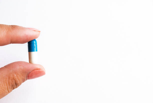 istock capsule in hand isolated on white background, copyspace for text, selective focus, top view. Pain drugs, health, pills for the treatment of the concept of addiction 1163787359