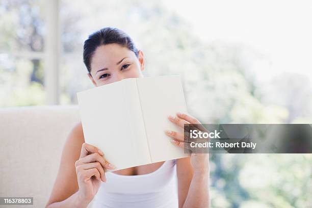Woman Holding Book Over Mouth Stock Photo - Download Image Now - Hiding, 25-29 Years, Adult