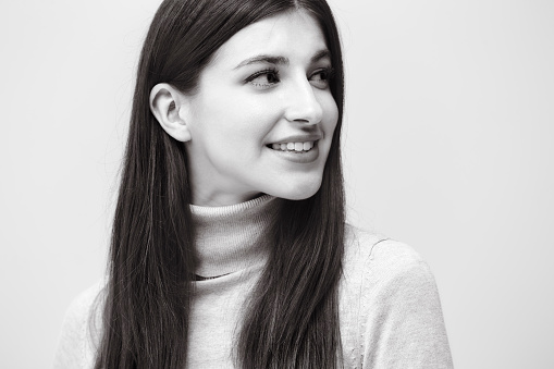 black and white portrait of a beautiful caucasian woman, happy and smiling, looking away