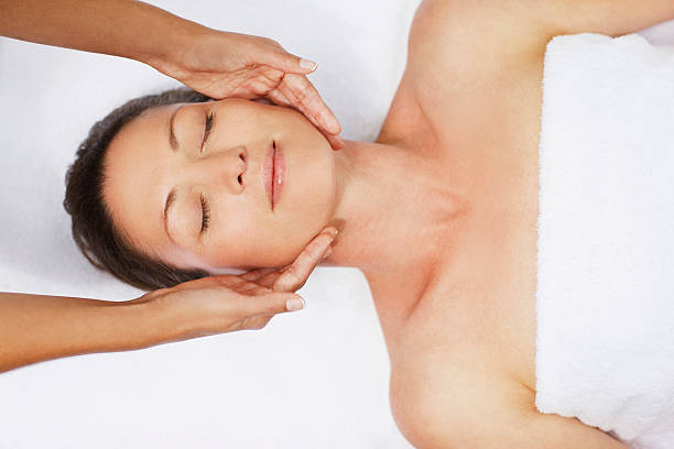 woman receiving facial massage - 臉部按摩 個照片及圖片檔