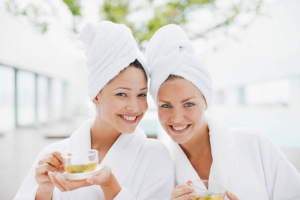 mujeres bebiendo té en el spa, batas de baño - bathrobe women cup towel fotografías e imágenes de stock