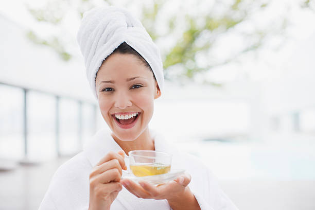 mujer con la cabeza envuelto en toalla bebiendo té - tea women beauty pampering fotografías e imágenes de stock
