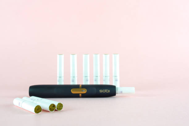 Newest IQOS electronic cigarette (heating tabacco system) on pink backgrounds. ROSTOV-ON-DON, RUSSIA - January 03, 2019: Newest IQOS electronic cigarette (heating tabacco system) on pink backgrounds. iqos e cig stock pictures, royalty-free photos & images