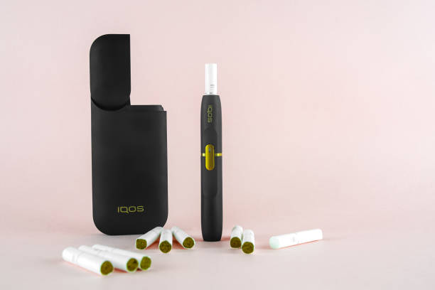 Newest IQOS electronic cigarette (heating tabacco system) on pink backgrounds. ROSTOV-ON-DON, RUSSIA - January 03, 2019: Newest IQOS electronic cigarette (heating tabacco system) on pink backgrounds. iqos e cig stock pictures, royalty-free photos & images