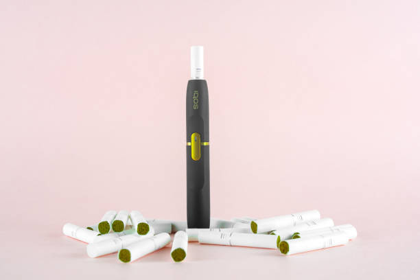 Newest IQOS electronic cigarette (heating tabacco system) on pink backgrounds. ROSTOV-ON-DON, RUSSIA - January 03, 2019: Newest IQOS electronic cigarette (heating tabacco system) on pink backgrounds. iqos e cig stock pictures, royalty-free photos & images