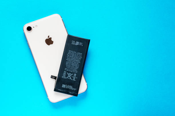애플 아이폰 6과 스마트 폰 애플 아이폰 8에서 리튬 이온 블랙 배터리는 파란색 배경에. 스마트폰의 손상된 오래된 배터리를 교체합니다. - battery replacement 뉴스 사진 이미지