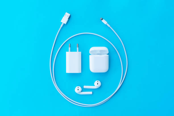 ROSTOV-ON-DON, RUSSIA - APRIL 28, 2018: Top view plastic white wireless Apple AirPods, charging case, Lighning USB, adapter on a pastel blue background for  Apple iPhone. New Apple Earpods Airpods in box.