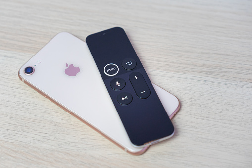 ROSTOV-ON-DON, RUSSIA - DECEMBER 20, 2018:   New Apple TV media streaming  player microconsole by Apple Computers futuristic touch remote swipe-to-select with integrated Siri  remote  and iphone 8