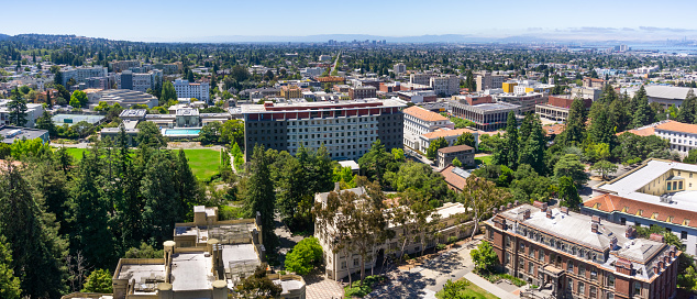 Panoramic view of UC Berkeley on a sunny day, view towards Oakland and the San Francisco bay shoreline in the background, California