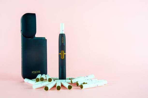 Newest IQOS electronic cigarette (heating tabacco system) on pink backgrounds. ROSTOV-ON-DON, RUSSIA - January 03, 2019: Newest IQOS electronic cigarette (heating tabacco system) on pink backgrounds. iqos e cig stock pictures, royalty-free photos & images