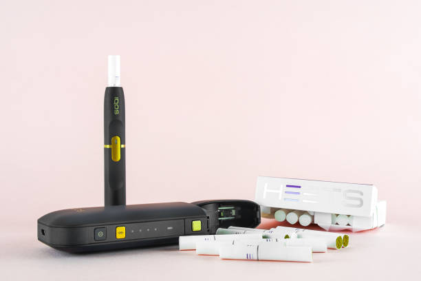 Newest IQOS electronic cigarette (heating tabacco system) on pink backgrounds. ROSTOV-ON-DON, RUSSIA - January 03, 2019: Newest IQOS electronic cigarette (heating tabacco system) on pink backgrounds. iqos e cig stock pictures, royalty-free photos & images