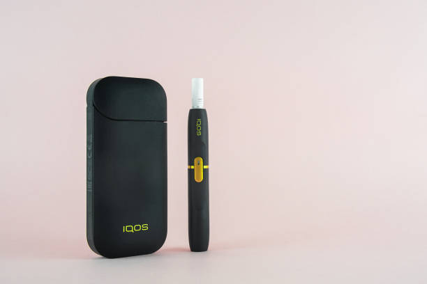 Newest IQOS electronic cigarette (heating tabacco system) on pink backgrounds. ROSTOV-ON-DON, RUSSIA - January 03, 2019: Newest IQOS electronic cigarette (heating tabacco system) on pink backgrounds. iqos e cig stock pictures, royalty-free photos & images