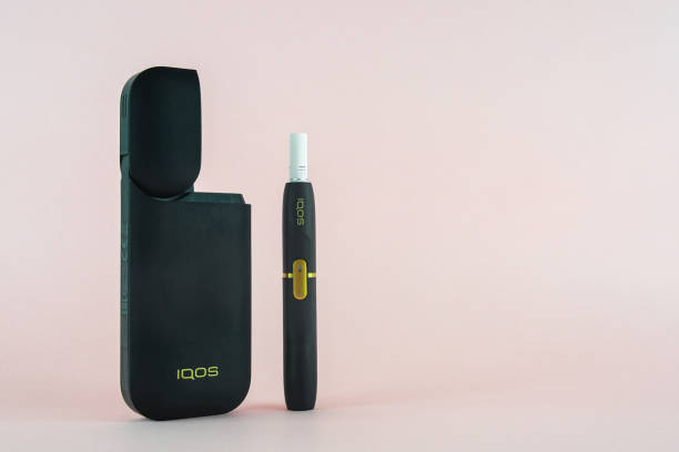 Newest IQOS electronic cigarette (heating tabacco system) on pink backgrounds. ROSTOV-ON-DON, RUSSIA - January 03, 2019: Newest IQOS electronic cigarette (heating tabacco system) on pink backgrounds. iqos e cig stock pictures, royalty-free photos & images