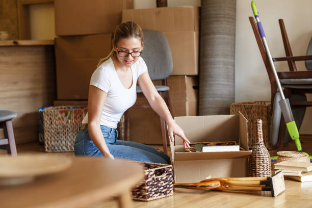istock Young woman unpacking cardboard boxes at new home. 1163794523