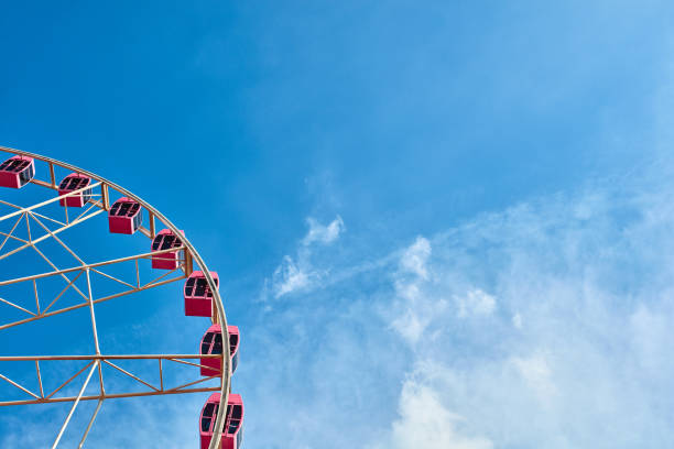 istock Pink ferris wheel in the blue sky and white clouds background 1163796388