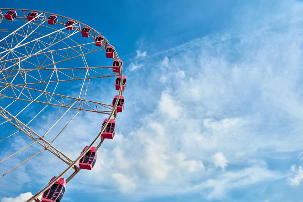 istock Pink ferris wheel in the blue sky and white clouds background 1163796470