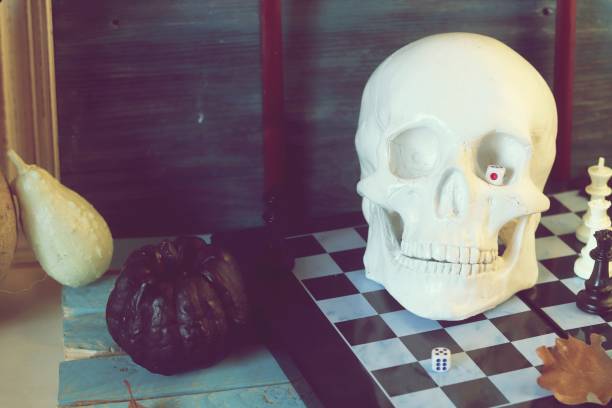 istock Decorative composition of a skull, pumpkins, frames and mystical decor on a chessboard with figures 1163799631