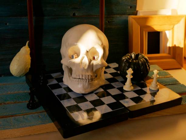 istock Decorative composition of a skull, pumpkins, frames and mystical decor on a chessboard with figures 1163799632