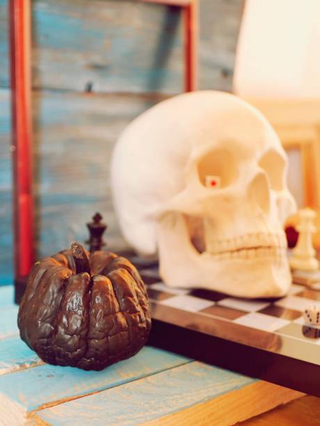 istock Decorative composition of a skull, pumpkins, frames and mystical decor on a chessboard with figures 1163799639