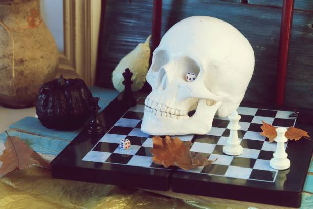 istock Decorative composition of a skull, pumpkins, frames and mystical decor on a chessboard with figures 1163799657