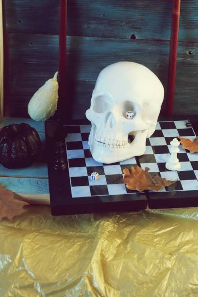istock Decorative composition of a skull, pumpkins, frames and mystical decor on a chessboard with figures 1163799658