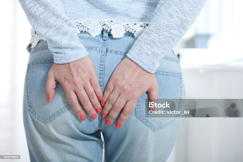 woman with haemorrhoids touching her bud with her hands woman with haemorrhoids touching her bud with her hands close up Buttocks Stock Photo