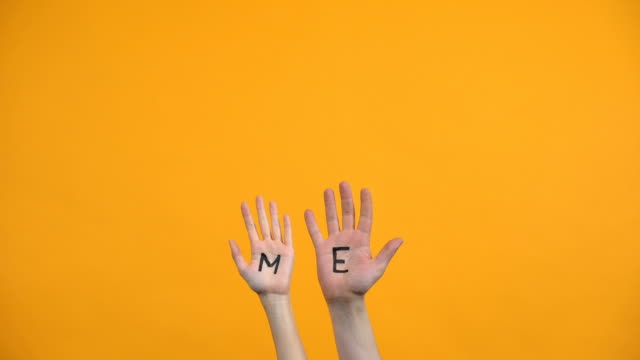 Me written on palms orange background, male and female volunteers, charity