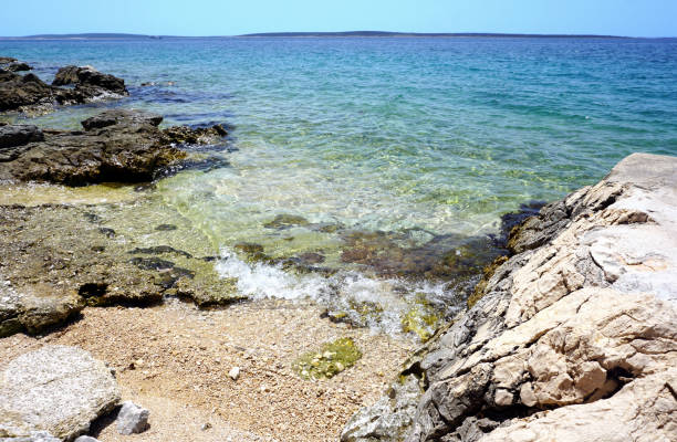 istock Wild sea coast blue lagoon with pebble beach. Nature background 1163806927