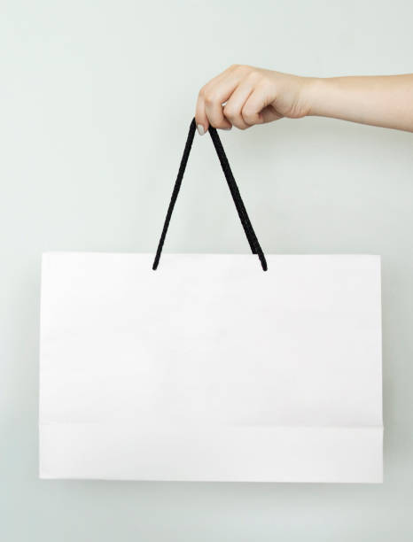istock Woman holding paper bag on gray background 1163810054