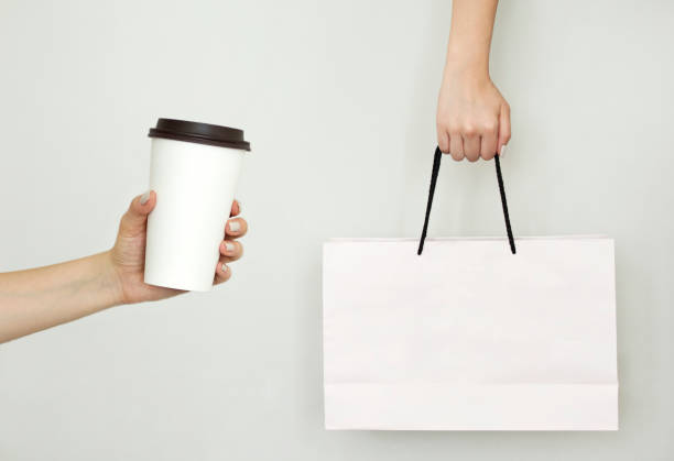 istock Hand holding white paper bag and cup 1163811789