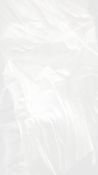 Vertical very gentle delicate dream beautiful elegant light white blur background - natural matte and shiny silk in drapery, folds, wrinkles for wedding cards, exquisite solemn backgrounds