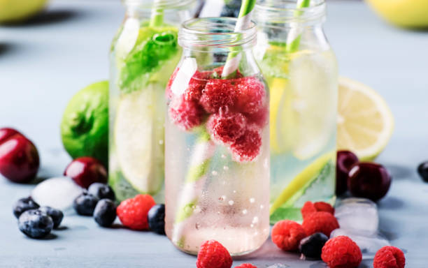 istock Summer drinks set. Berry, fruit and citrus non-alcoholic refreshing ice cold beverages and cocktails in glass bottles on blue background 1163813323