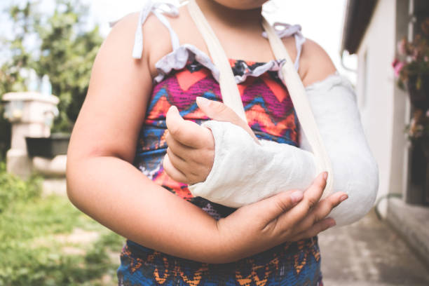 Child with a broken arm. Close up hand with bandage and gypsum stock photo