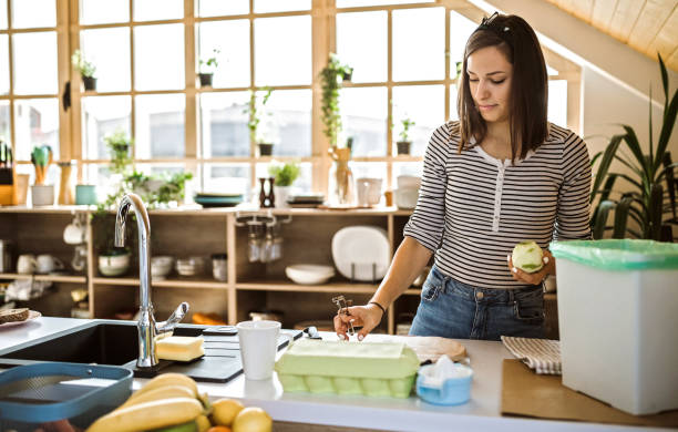 istock Millennial woman putting organic waste in compost bin 1163817119