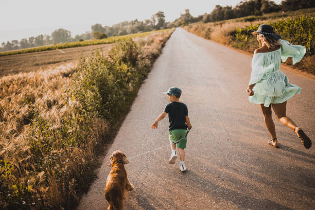 istock Little boy playing with his mother and dog 1163818235