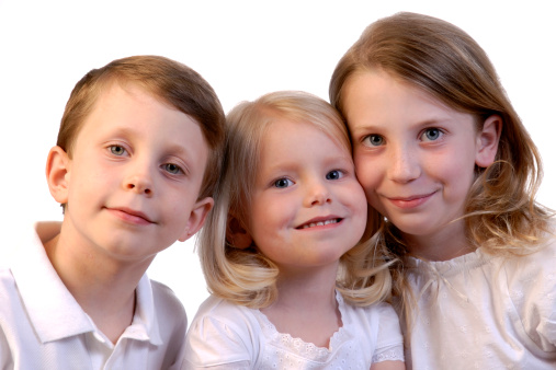A high key portrait of a brother with his two sisters
