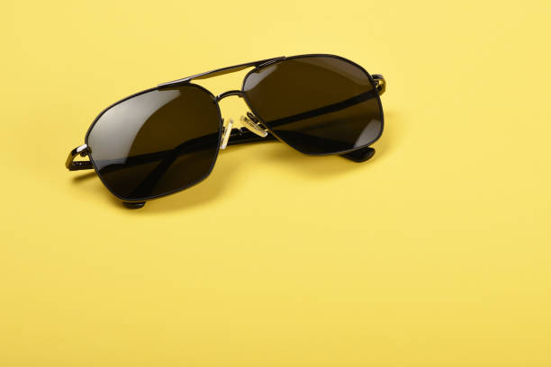 istock Sunglasses on the yellow background 1163819310