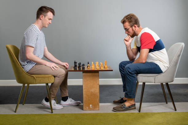 istock Two Young Male Friends Play Chess On A Make Shift Table 1163820476