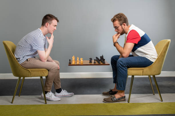 istock Two Friends Play Chess On A Floating Chess Board 1163820480
