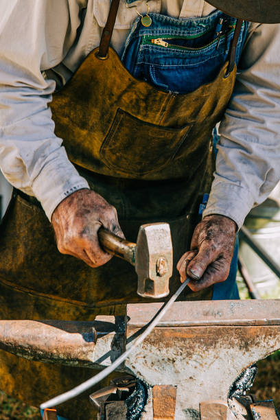 istock Working man hammering hot piece of iron 1163823611