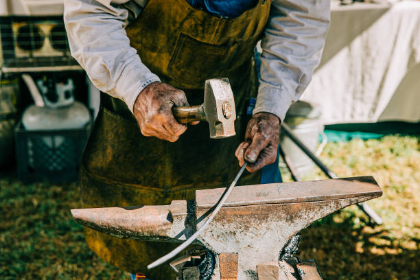 istock Working man hammering hot piece of iron 1163823621