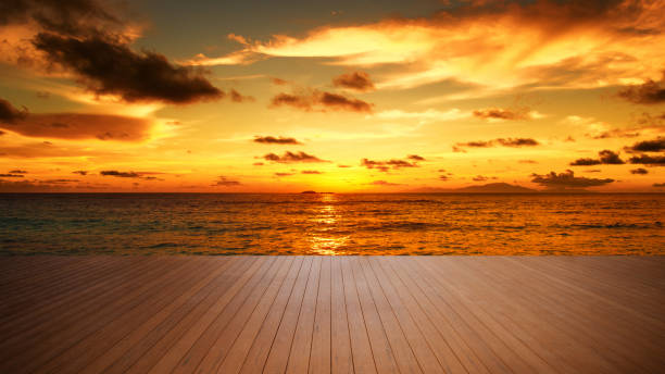Empty wooden platform beside tropical sea with sunset