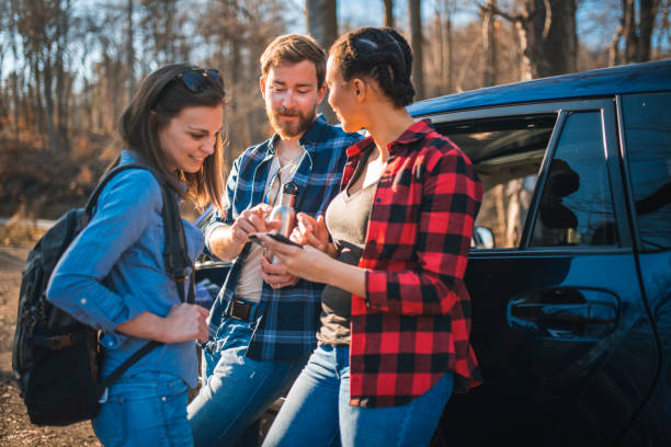 istock Friends standing in a forest, next to a car and talking 1163827676