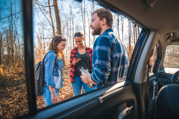 istock Friends standing in a forest, next to a car and talking 1163827682